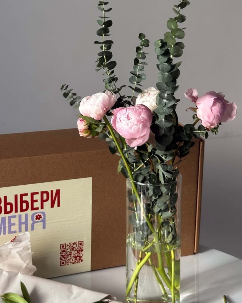 Пионы в вазе рядом с фирменной коробкой